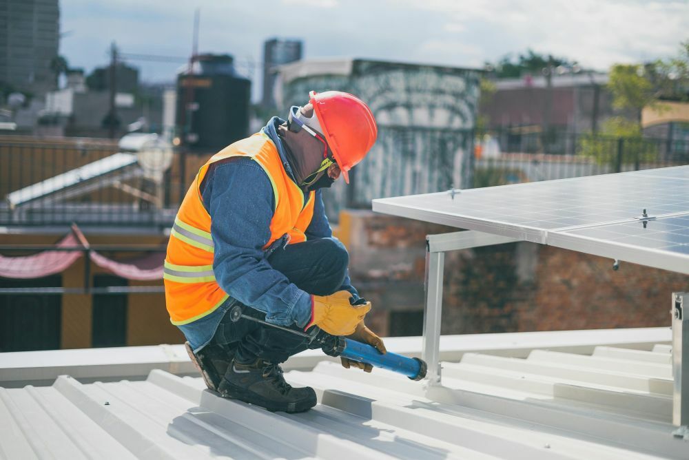 A worker installing a solar panel on a roof