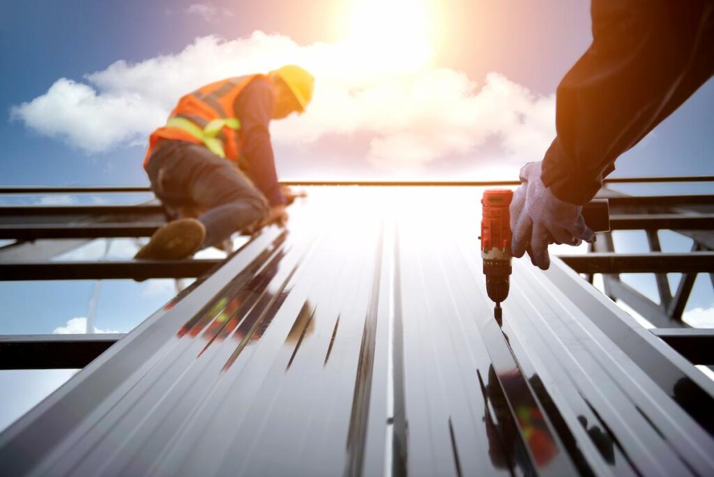 Roofer works on the roof structure of a building at a construction site.
