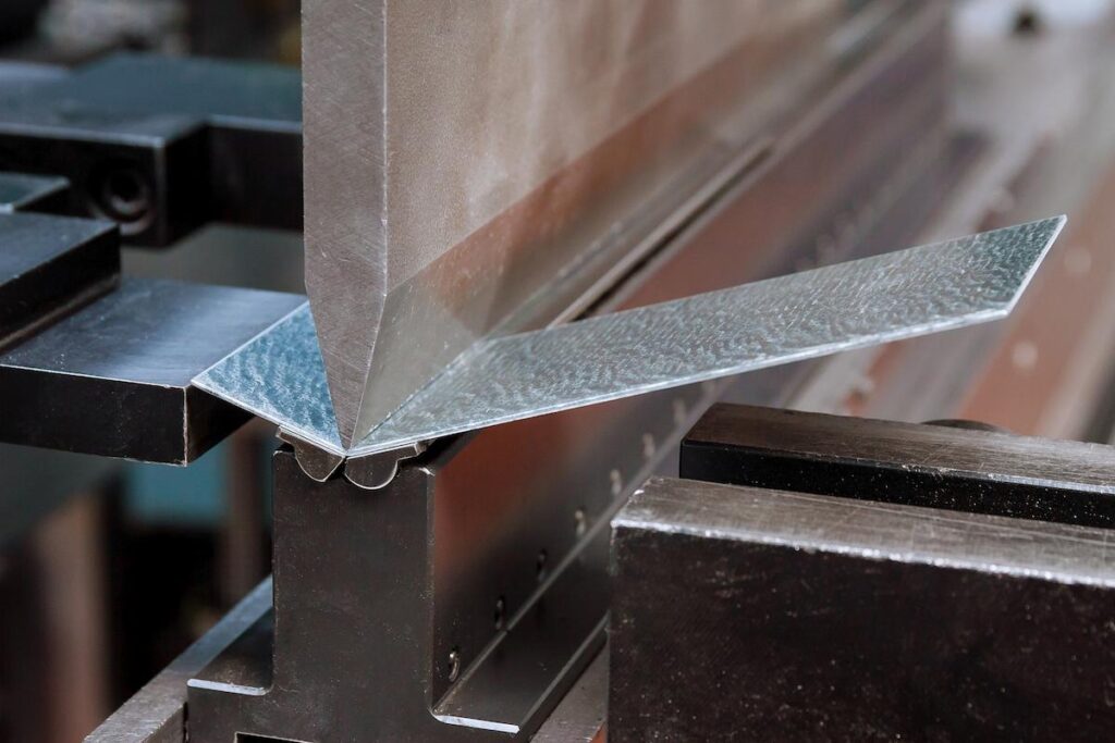 Bending sheet metal on a hydraulic machine at the factory. Close-up.